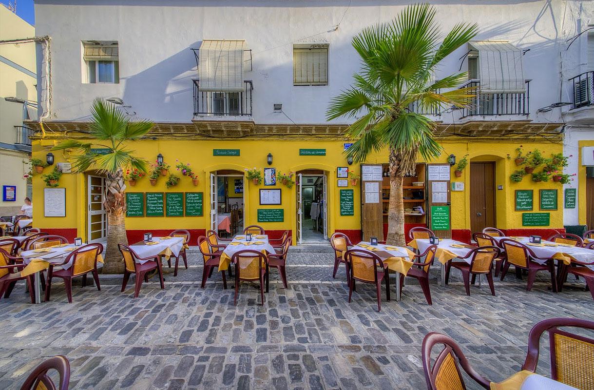 Mesas en la entrada del Restaurante Mesón Criollo en Cádiz